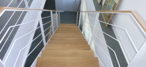 Escalera con peldaños y pasamano de madera de roble.