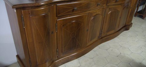 Mueble comedor curvado, fabricado en madera maciza de nogal. Incrustaciones de marquetería de boj en  puertas y cajones.