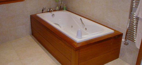 Bañera de hidromasage forrada en madera maciza de iroco.